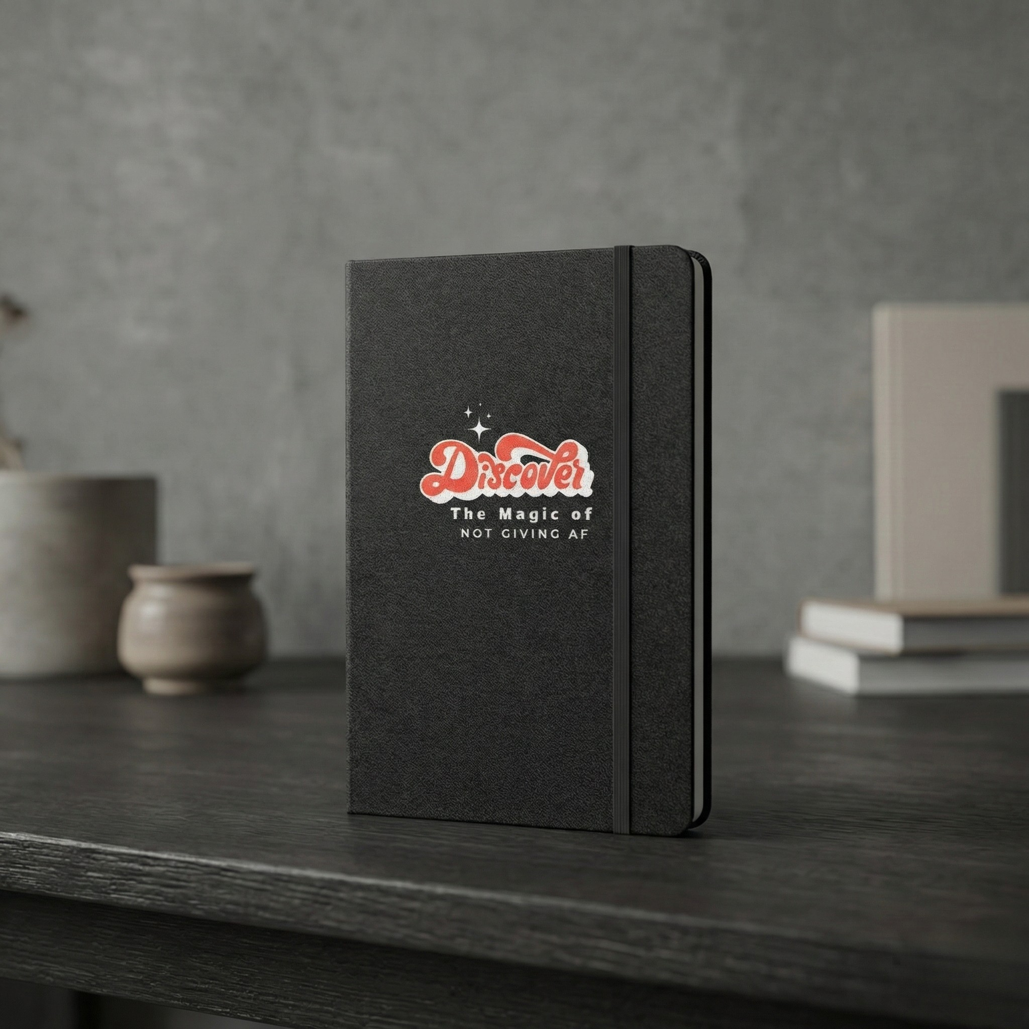 Black notebook with a logo on a wooden surface