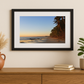 Framed beach print on a wall above a wooden console table with decorative items.