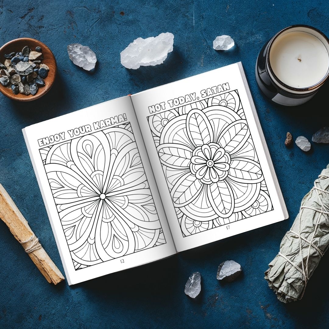 Coloring book open to mandala pages with crystals and a candle on a blue surface