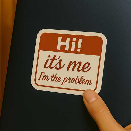 Sticker with 'Hi! it's me I'm the problem' text on a black background