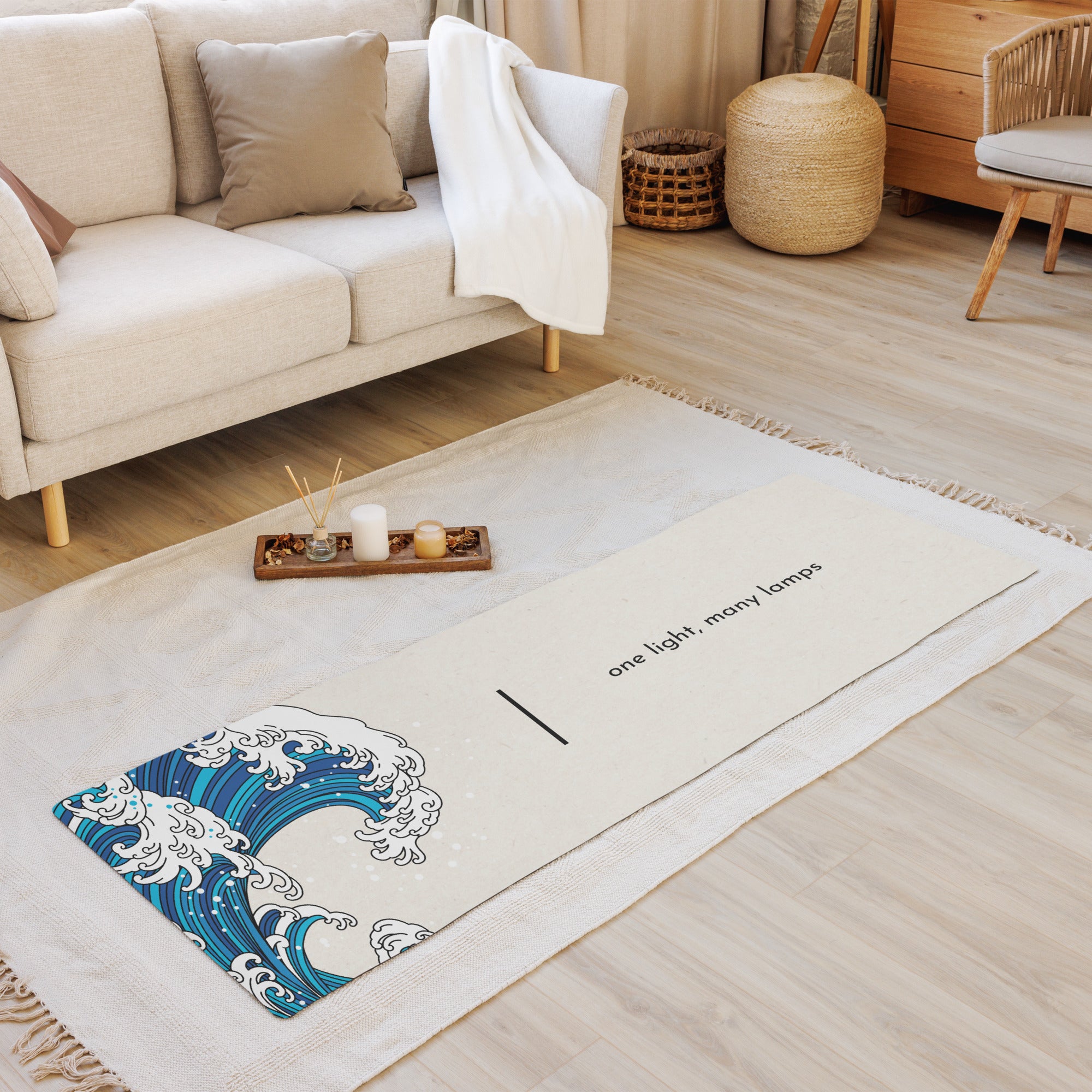 A yoga mat with a white and blue wave pattern and text on it, placed on a wooden floor in a cozy living room setting.