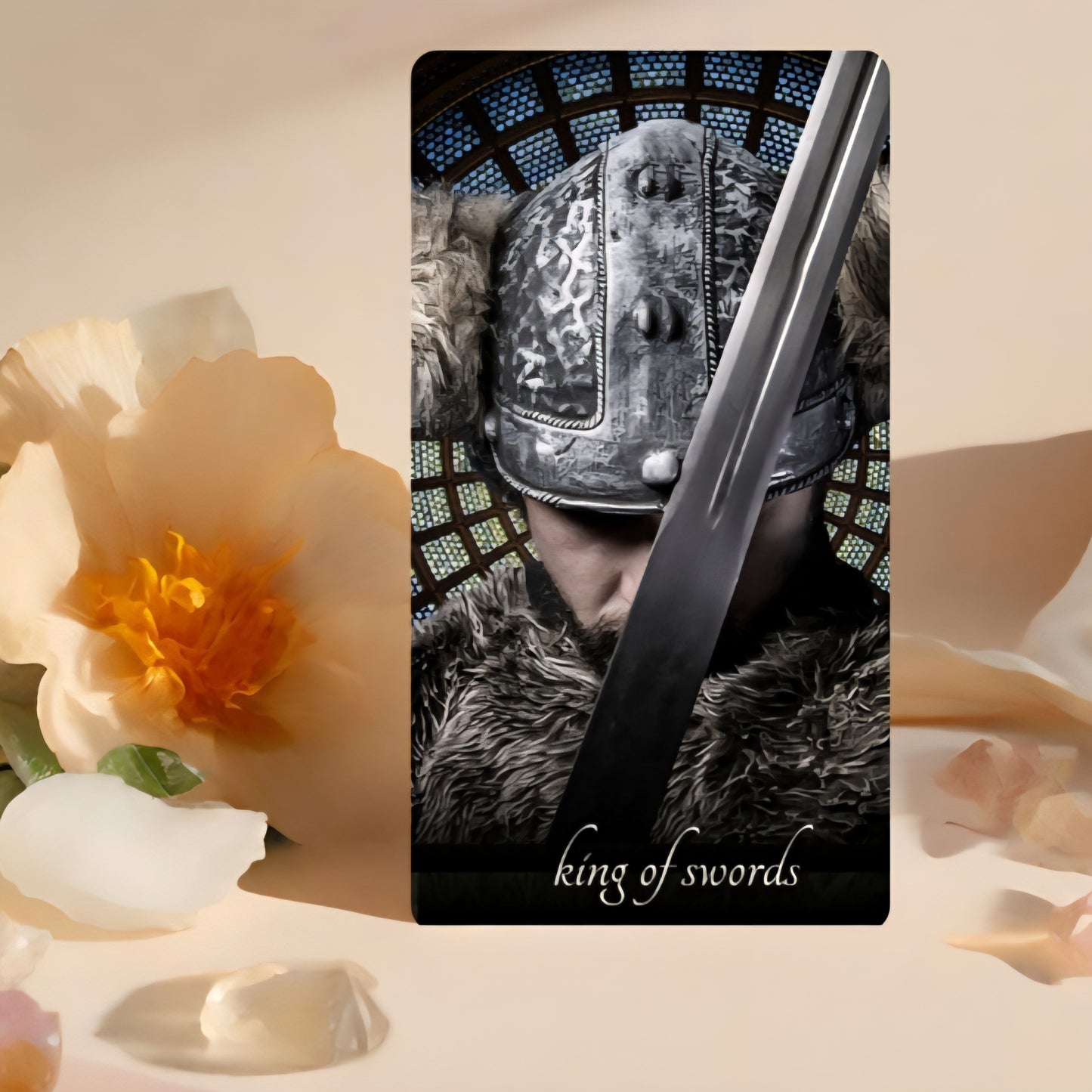 Card featuring a warrior with a sword labeled 'King of Swords' on a decorative background with flowers.