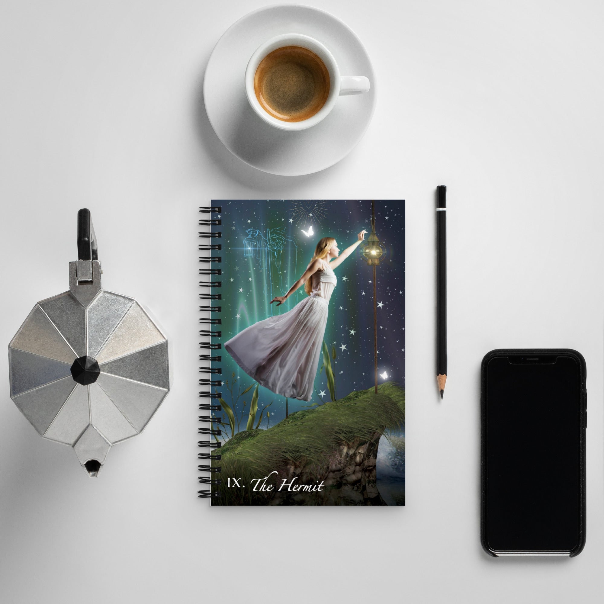 The Hermit Spiral Bound Notebook lies flat on a table with a morning espresso and phone