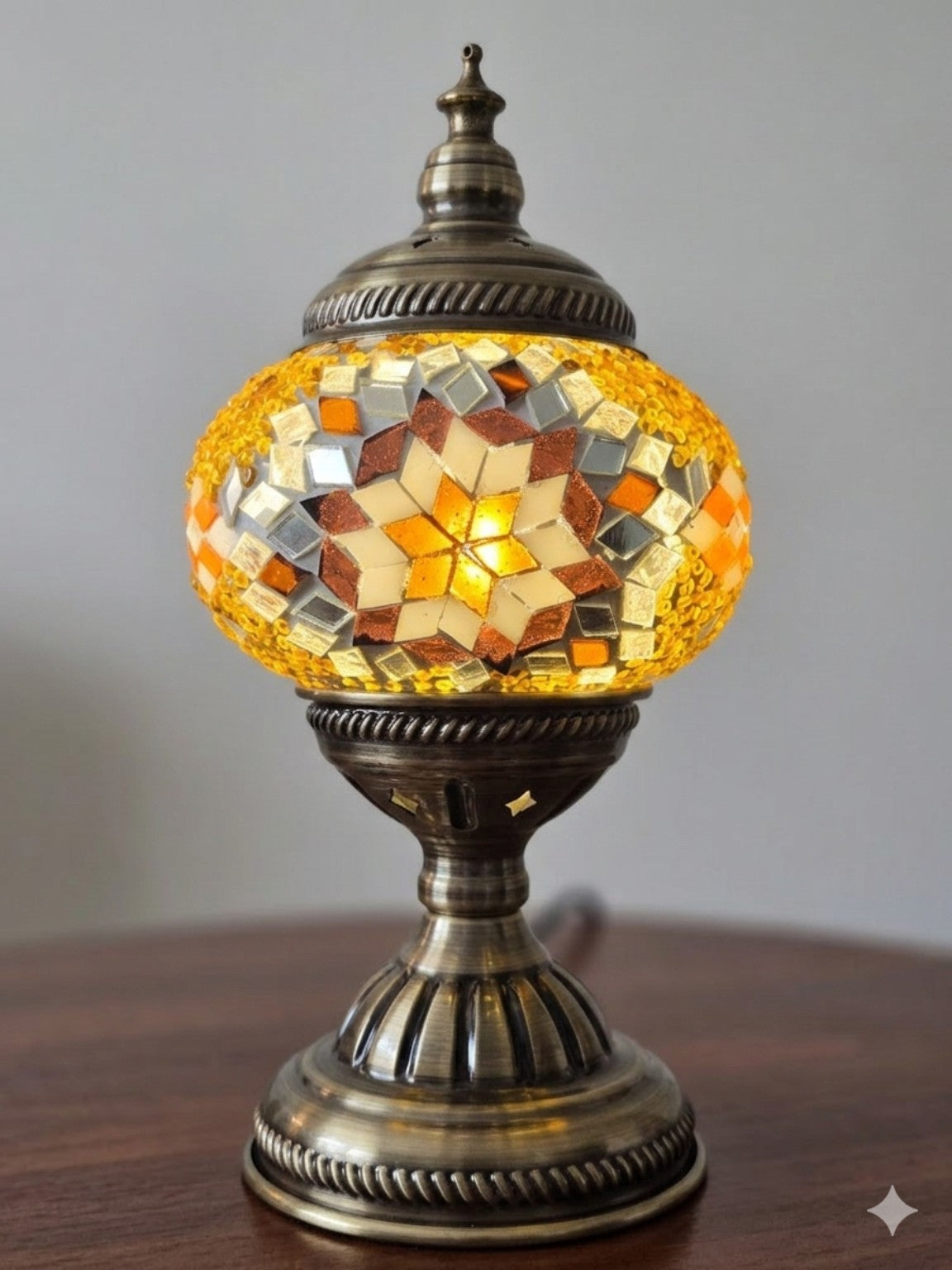 Golden Star Turkish Mosaic Lamp placed elegantly in a cozy space, radiating soft golden light for ambiance.